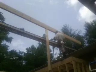 Carpenter setting a ridge beam over a new addition frame — Ice Dam Removal by Roofing Brothers in Forks Of Salmon